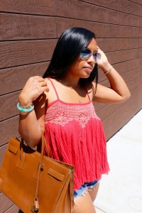 Tanya Major wearing Ray Ban shades, Free People top, cut-off shorts, Saint Laurent handbag, YSL high heels