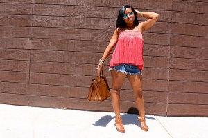 Tanya Major wearing Ray Ban shades, Free People top, cut-off shorts, Saint Laurent handbag, YSL high heels