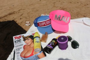 Maui beach with sunscreen, sun tanning oil, Bronzing spray that smells like coconut, a speaker and a fresh crispy magazine